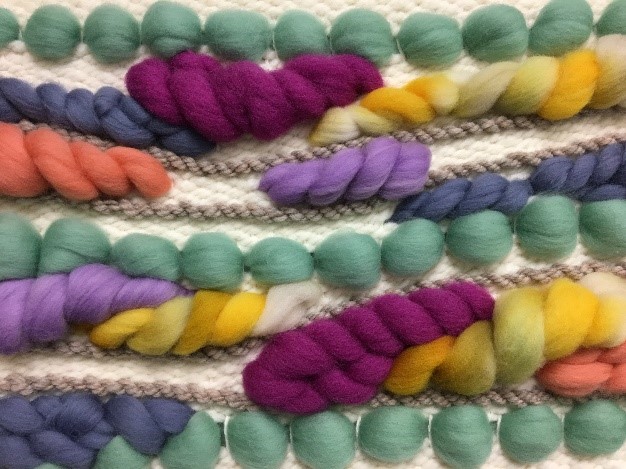 a close up of colorful yarns on a white background.